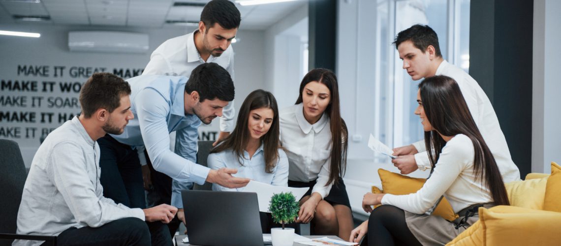 guy-shows-document-girl-group-young-freelancers-office-have-conversation-working